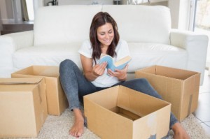 woman-looking-at-book-from-moving-box